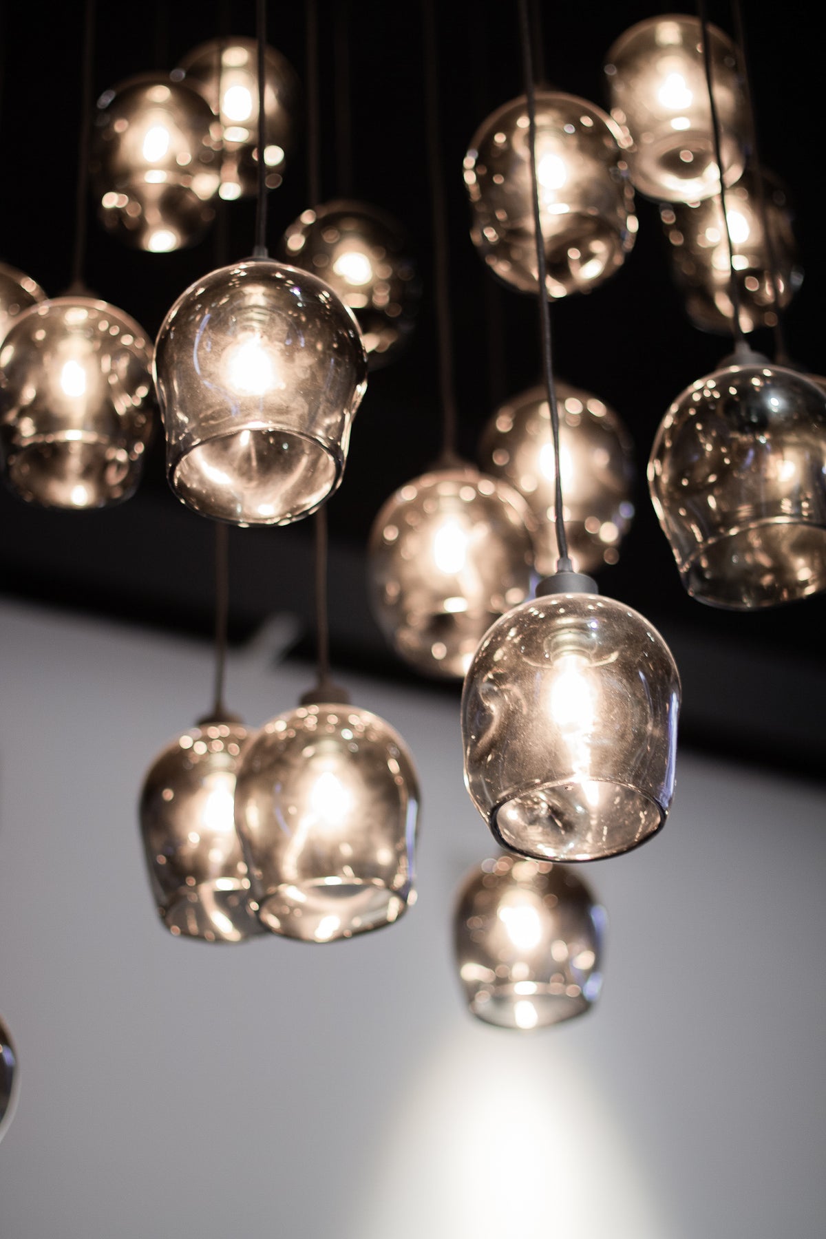 Westervilla restaurant styled by Berries Agency: cluster of smoked glass pendant lights glowing against a dark ceiling