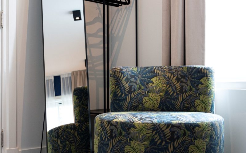 Westervilla hotel room styled by Berries Agency: botanical-print velvet armchairs by the window and a black standing mirror