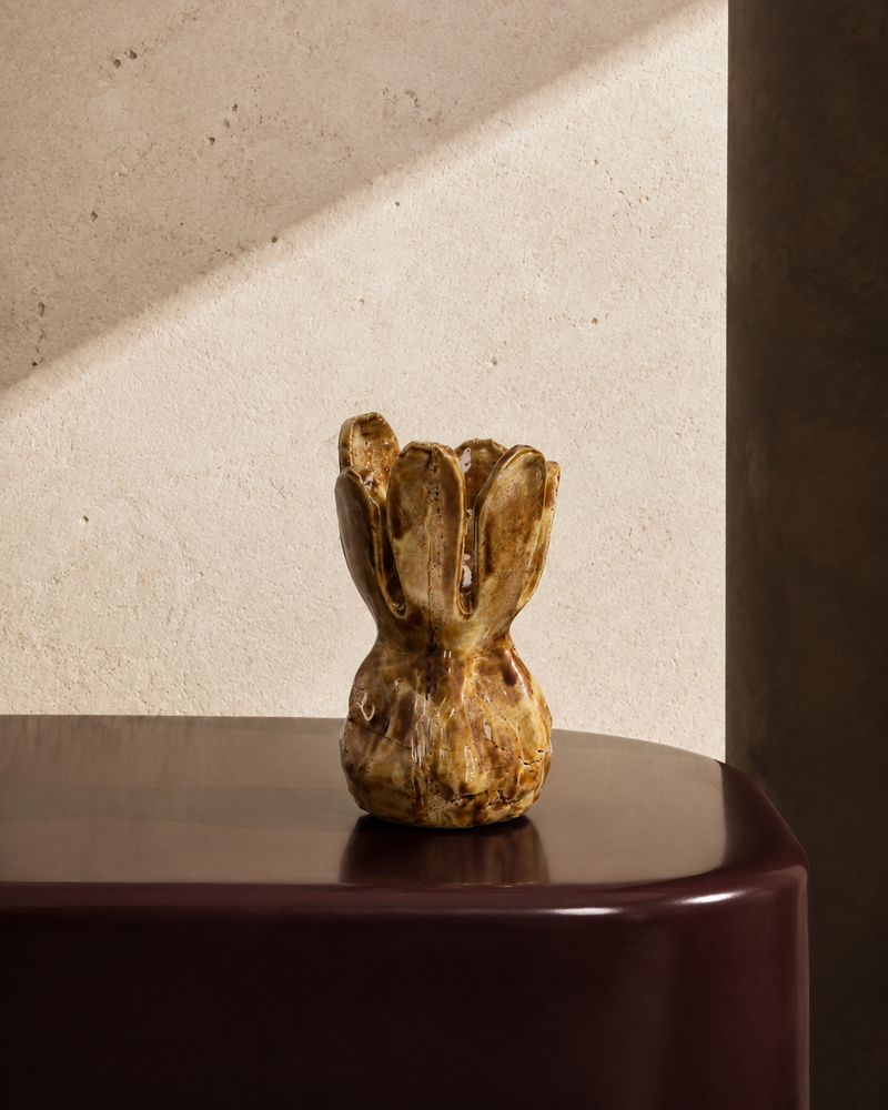 Small tulip-shaped stoneware vase in amber-brown glaze with petal rim, styled on a tabletop