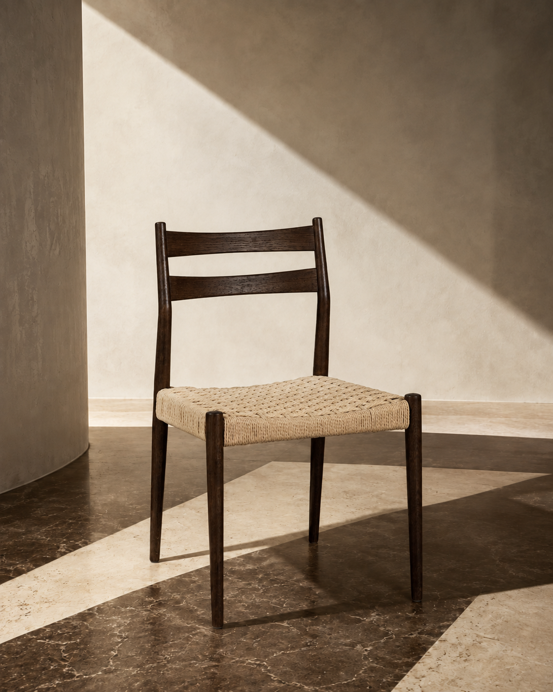 Dark oak dining chair without armrests and natural woven cord seat, styled in a sunlit interior